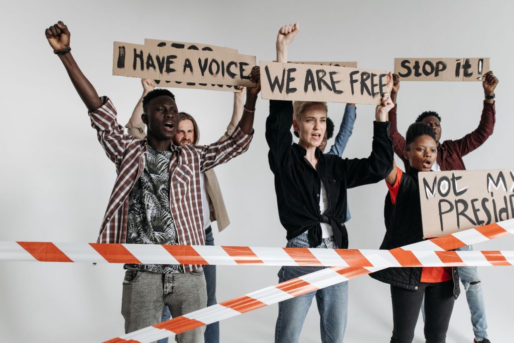 Protesters holding signs demanding freedom and voicing opinions.